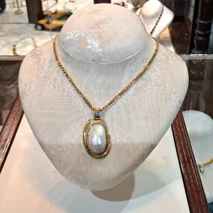 Necklace with a 18k gold medallion mother of pearl and a bleu topaz in a hand made 18k. gold chain